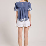 Embroidered Blouse With White Denim Shorts.