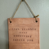"don't stumble over something behind you" Hanging Wall Sign