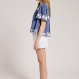 Embroidered Blouse With White Denim Shorts.